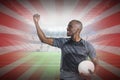 Composite image of sportsman with clenched fist holding rugby ball after victory Royalty Free Stock Photo