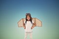 Composite image of standing girl with fake wings pretending to be pilot Royalty Free Stock Photo