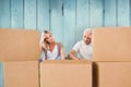 Composite image of stressed couple looking at moving boxes