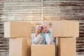 Composite image of stressed older couple with moving boxes