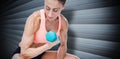 Composite image of strong woman doing bicep curl with blue dumbbell Royalty Free Stock Photo