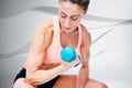 Composite image of strong woman doing bicep curl with blue dumbbell Royalty Free Stock Photo