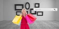 Composite image of stylish blonde in red dress holding shopping bags Royalty Free Stock Photo