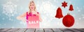 Composite image of stylish blonde in red dress showing sale bag Royalty Free Stock Photo