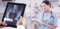 Composite image of surgeon using digital tablet with group around table in hospital Royalty Free Stock Photo