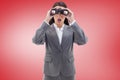 Composite image of surprised businesswoman looking through binoculars Royalty Free Stock Photo