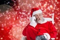 Composite image of surprised santa claus comunicating on mobile phone