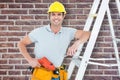 Composite image of technician holding drill machine while leaning on step ladder Royalty Free Stock Photo