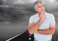 Composite image of thoughtful caucasian senior man against road and thunderstorm in dark sky Royalty Free Stock Photo