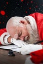 Composite image of tired santa claus napping at desk while writing a letter with a quill Royalty Free Stock Photo