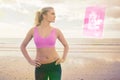 Composite image of toned woman with hands on hips on beach Royalty Free Stock Photo