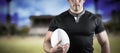 Composite image of tough rugby player holding ball Royalty Free Stock Photo