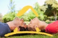 Composite image of two smiling friends with their eyes closed while lying head to head