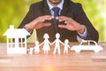 Composite image of underwriter protecting family in paper with his hands Royalty Free Stock Photo