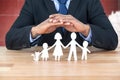 Composite image of underwriter protecting family in paper with his hands Royalty Free Stock Photo