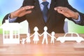 Composite image of underwriter protecting family in paper with his hands Royalty Free Stock Photo