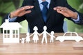 Composite image of underwriter protecting family in paper with his hands Royalty Free Stock Photo