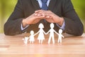 Composite image of underwriter protecting family in paper with his hands Royalty Free Stock Photo