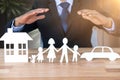 Composite image of underwriter protecting family in paper with his hands Royalty Free Stock Photo