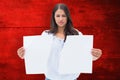 Composite image of upset brunette holding torn paper