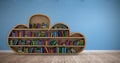 Composite image of various colourful books arranged on wooden shelves