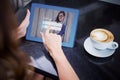 Composite image of woman having coffee and using her tablet