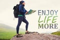 Composite image of woman standing on a rock holding map