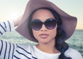 Composite image of Woman in summer hat against sea with flare Royalty Free Stock Photo