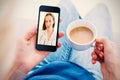 Composite image of woman using her mobile phone and holding cup of coffee Royalty Free Stock Photo