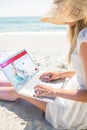 Composite image of woman using laptop and wearing hat Royalty Free Stock Photo