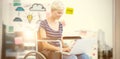 Composite image of woman in wheelchair using computer Royalty Free Stock Photo