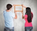 Composite image of young couple hanging a frame Royalty Free Stock Photo