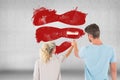 Composite image of young couple painting with roller Royalty Free Stock Photo