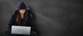 Composite image of young female hacker using laptop while sitting Royalty Free Stock Photo