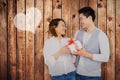 Composite image of young man giving present to woman Royalty Free Stock Photo