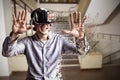 Composite image of young man using black virtual reality glasses by table Royalty Free Stock Photo