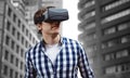 Composite image of young man wearing virtual reality glasses Royalty Free Stock Photo