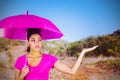 Composite image of young woman carrying pink umbrella Royalty Free Stock Photo