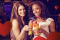 Composite image of young women toasting cocktail glasses at bar counter Royalty Free Stock Photo