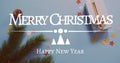 Composite of merry christmas greetings text over christmas decorations Royalty Free Stock Photo