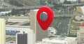 Composite of red gps pointer over tilt shift cityscape with bridges and moving vehicles, copy space