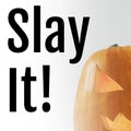 Composite of slay it text and carved halloween pumpkin on white background