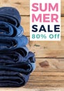 Composite of summer sale 80 percent off text over denim trousers on wooden background