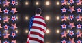 Composition of american flag stars and man wrapped in american flag over sports stadium spotlights