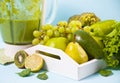 Composition with assorted raw organic green vegetables and friuts on the white wooden tray and blender Royalty Free Stock Photo