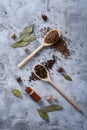 Composition of assortment of spices in the wooden spoons on the white background, flat lay, close-up, selective focus.