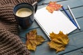 Composition with autumn leaves, blank notebooks, a cup of coffee on a blue wooden table Royalty Free Stock Photo