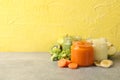 Composition baby food on gray table against yellow background