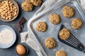 Composition of a baking tray with freshly baked chickpea cookies and dark chocolate chips, some ingredients and a