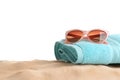 Composition with beach sand, sunglasses and towel on white background